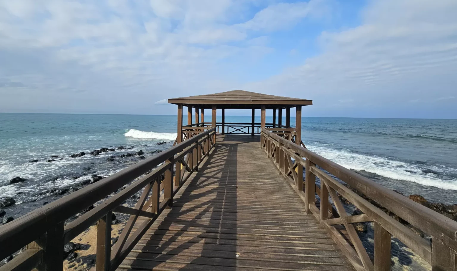 Wooden deck overlooking the rocky coastline and ocean in São Tomé and Príncipe.