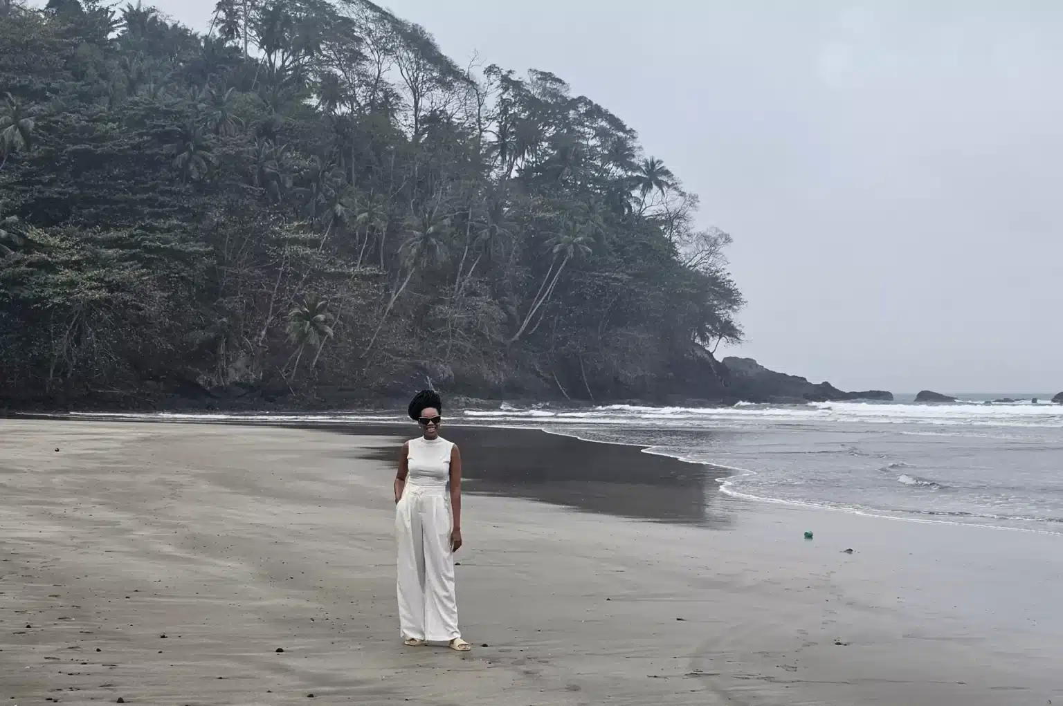 Angela Blair Cadet standing on a beach in São Tomé and Príncipe.